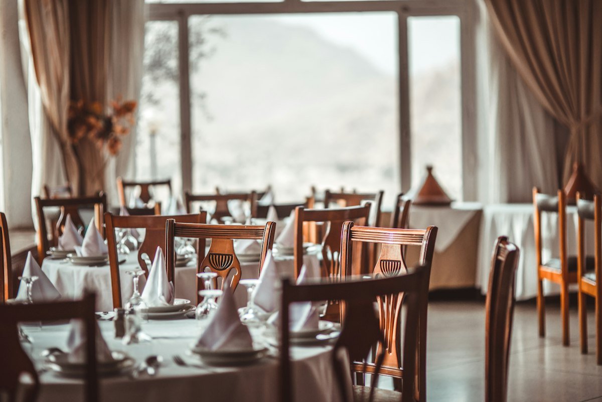 Restaurant dining room with wooden tables, chairs and pendant lighting