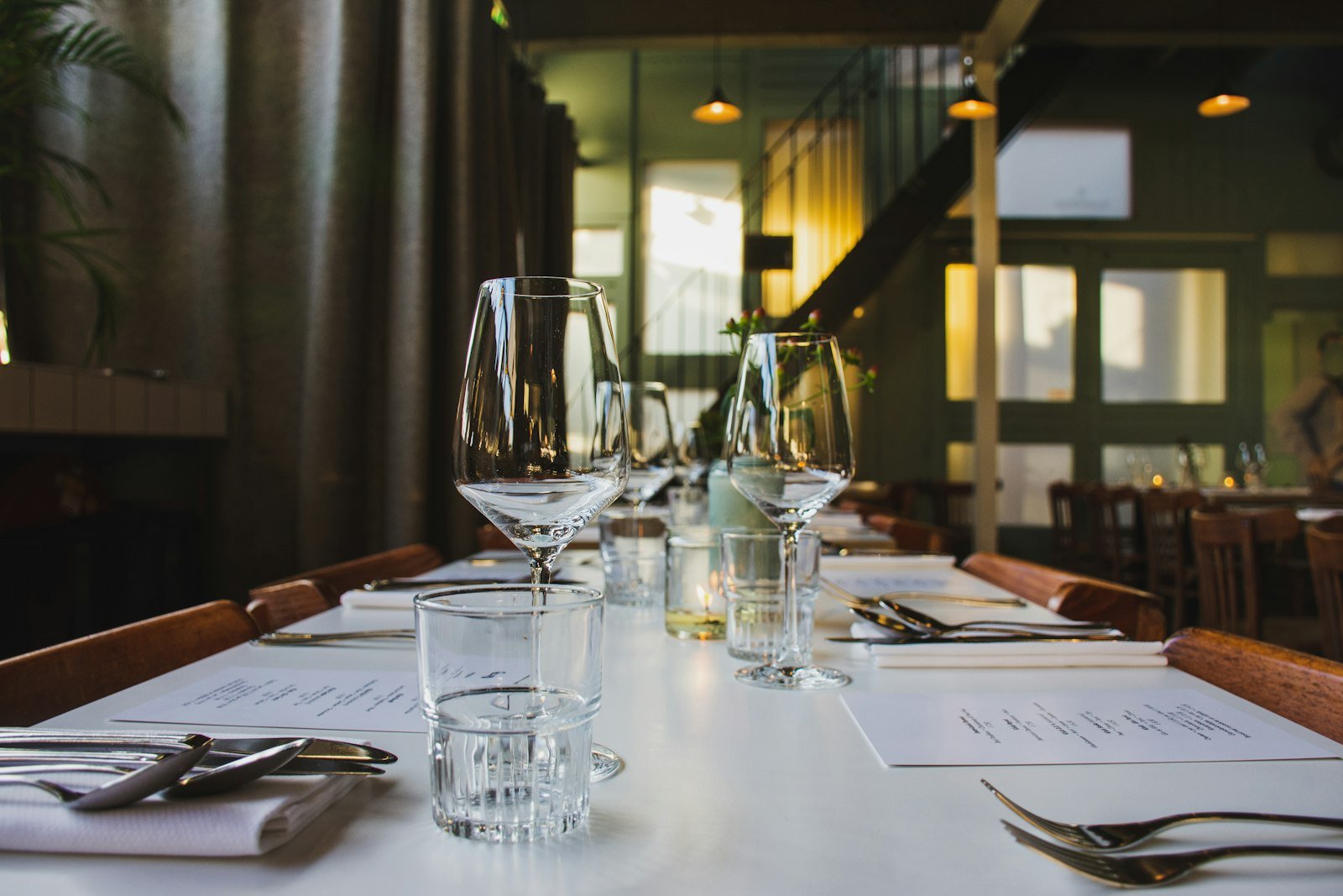 Clear wine glasses set on a restaurant dining table