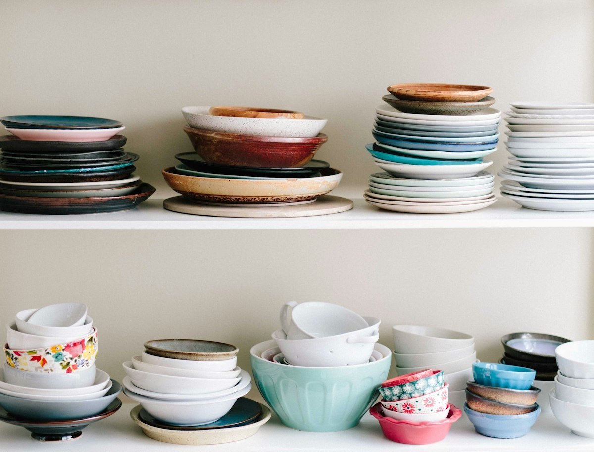 Stacks of ceramic bowls, plates and saucers on open shelving